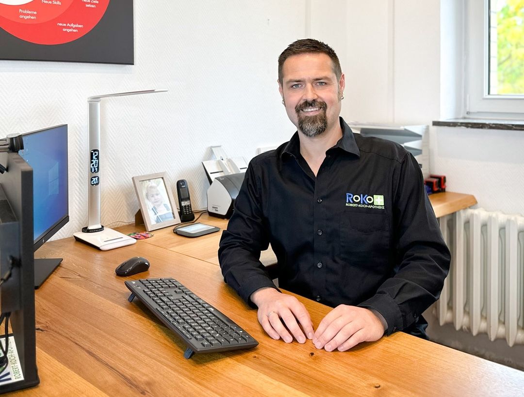 Apotheker am Schreibtisch im Backoffice der RoKo-Apotheken