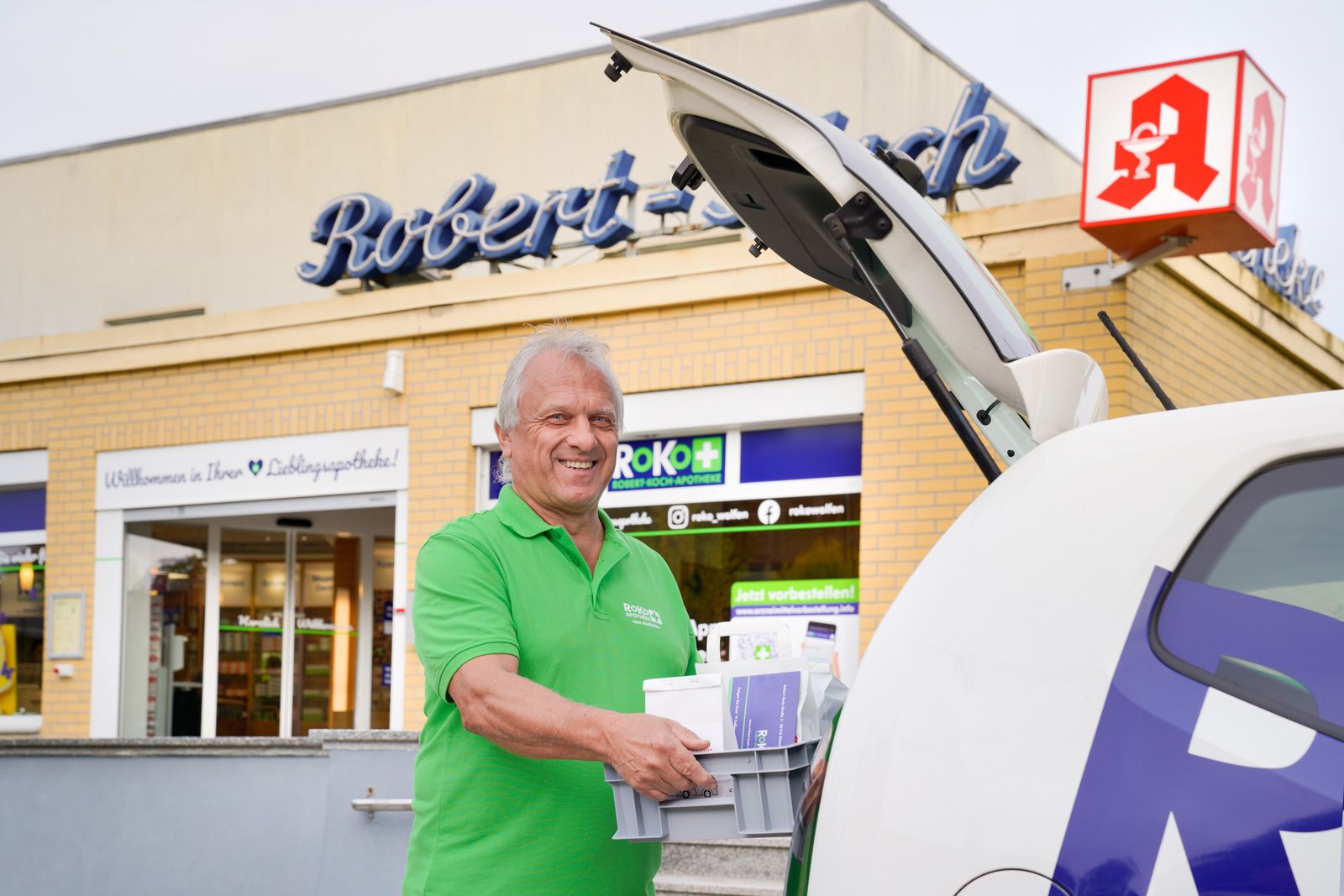 RoKo-Mitarbeiter belädt das Botendienst-Fahrzeug vor der Robert-Koch-Apotheke