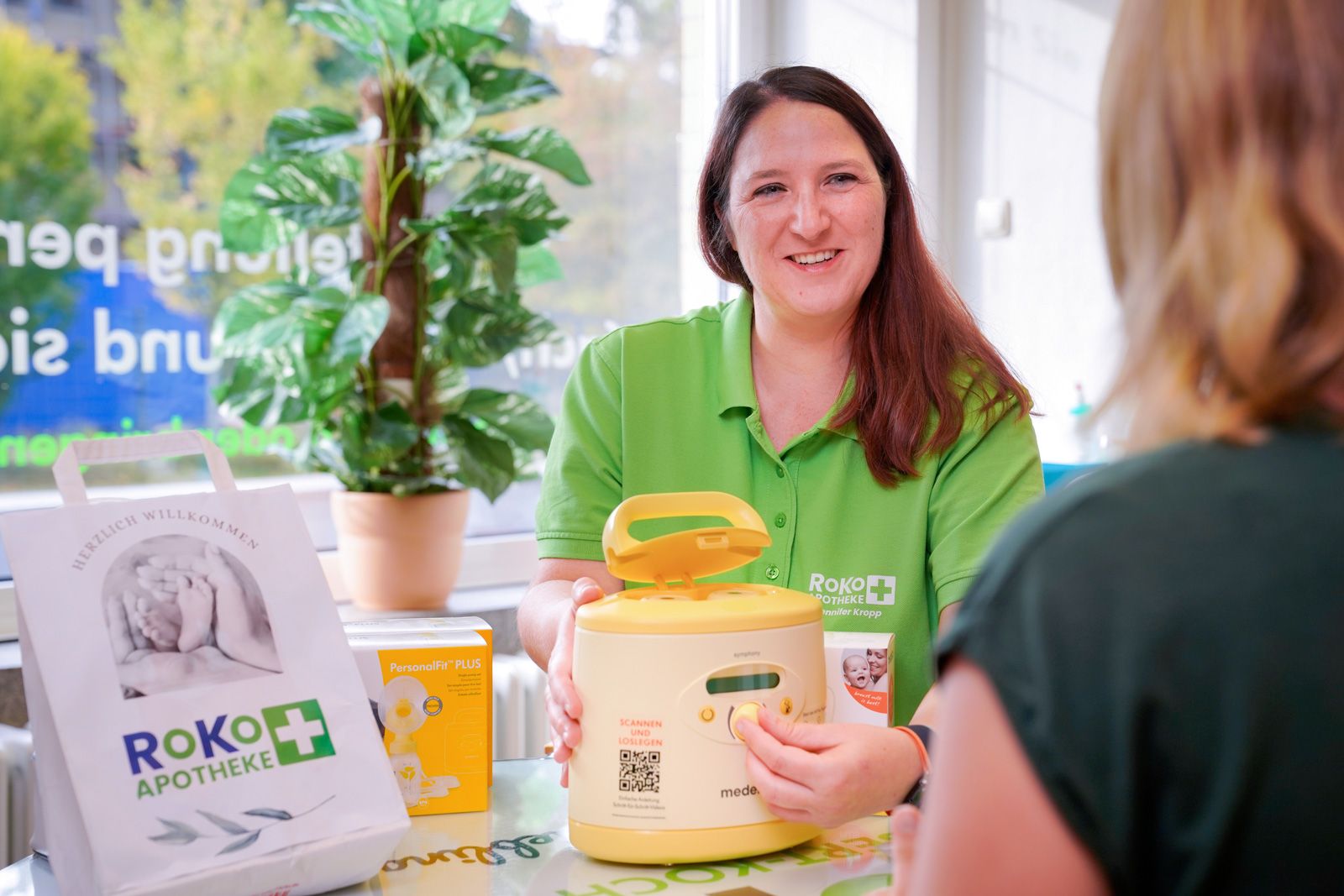 RoKo-Apothekerin zeigt einer Kundin eine Medela-Milchpumpe zum Verleih
