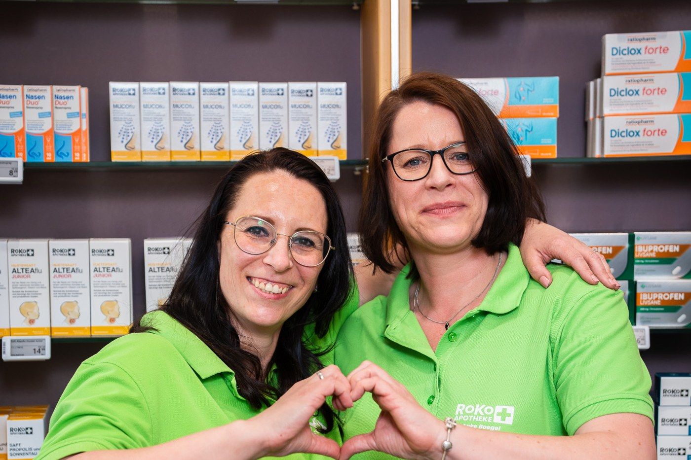 Zwei RoKo-Mitarbeiterinnen formen mit den Händen gemeinsam ein Herz