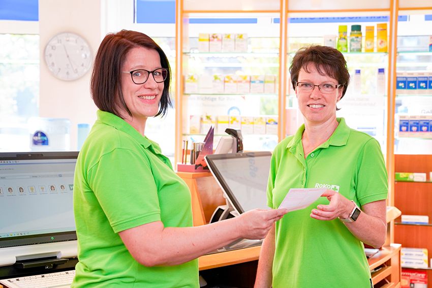Zwei Mitarbeiterinnen der RoKo-Apotheken mit einem Rezept in der Hand